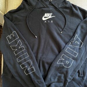 Nike black cropped hoodie with white Nike logo on the front and down the sleeves